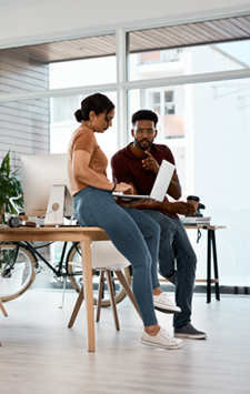 man and woman sitting on a desk